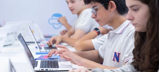 Alumnos escribiendo en netbooks de perfil