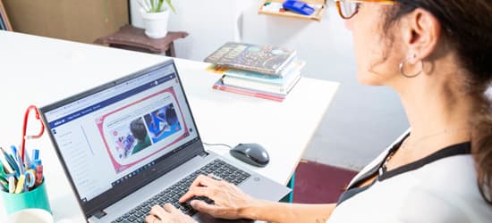 Docente escribiendo en computadora